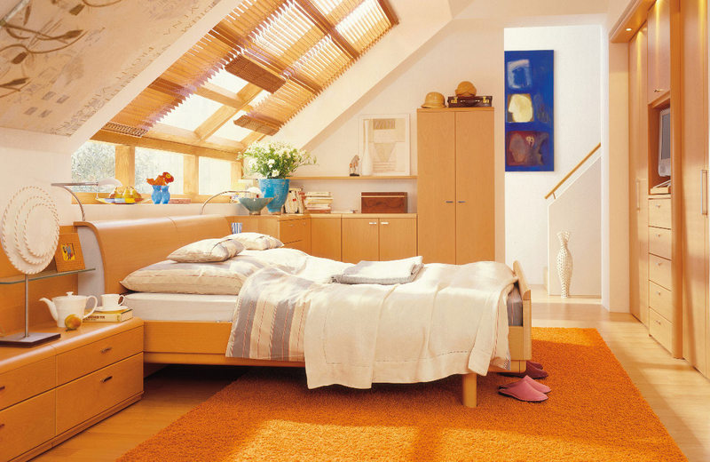bedroom_with_low_roof_and_orange_cool_themed_wooden_simple_furniture.jpg